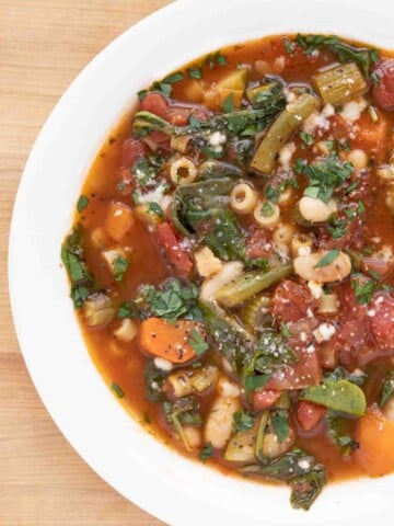 overhead partial shot of minestrone in a white bowl