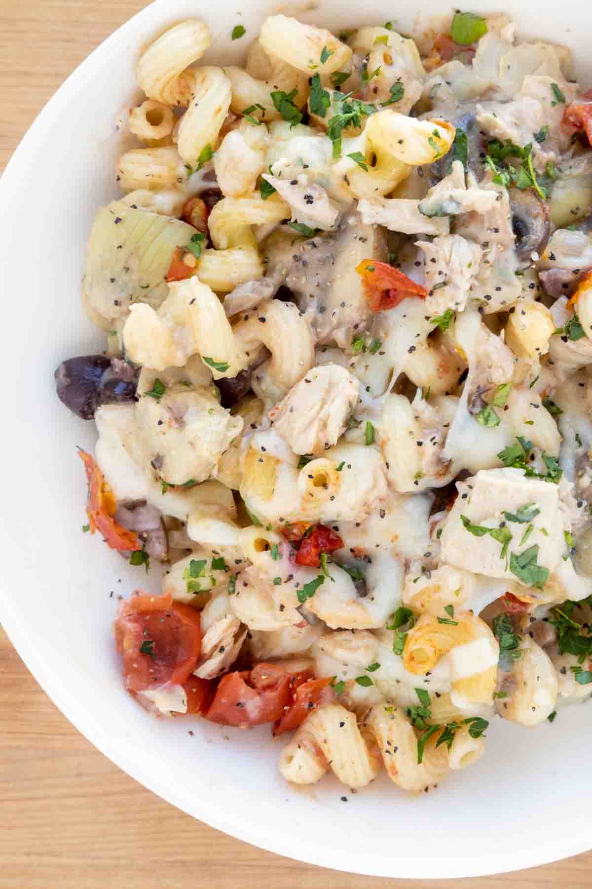 overhead partial view of mediterranean style tuna casserole in a white bowl