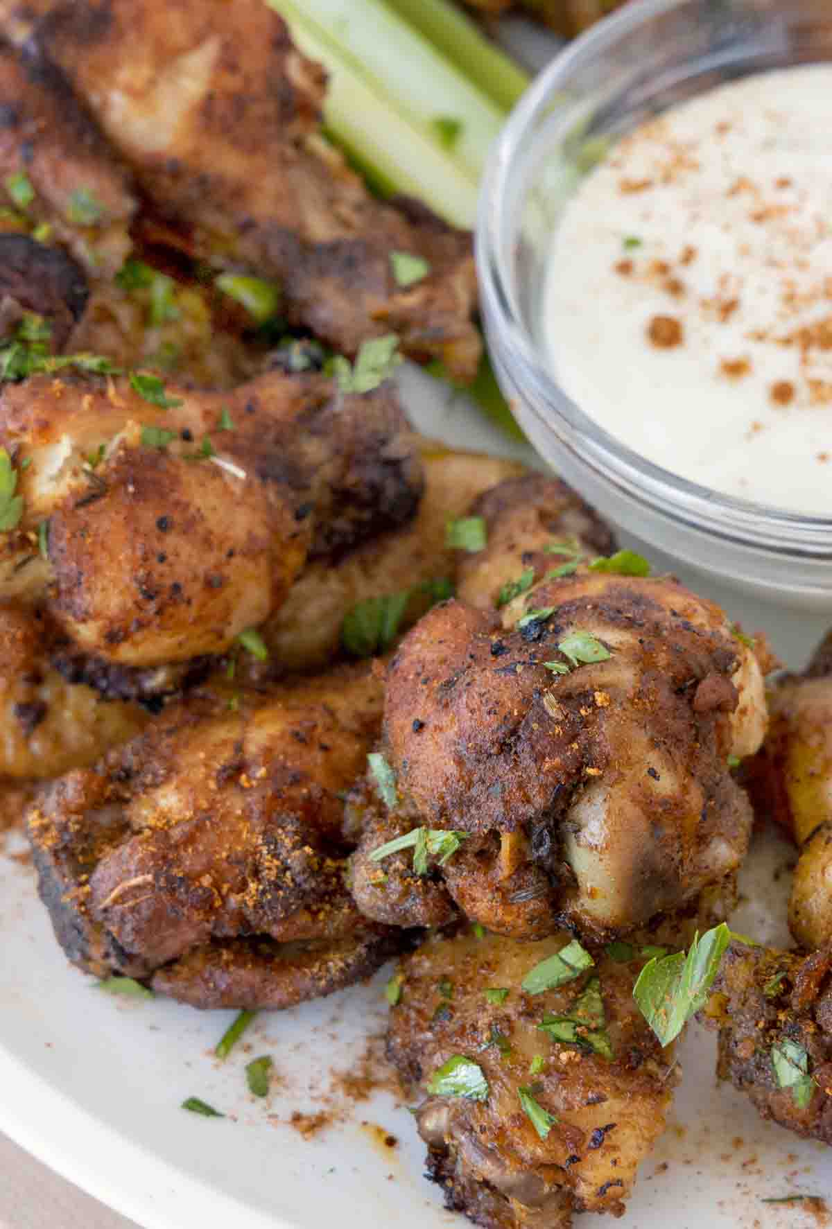 cajun wings on white plate with dip