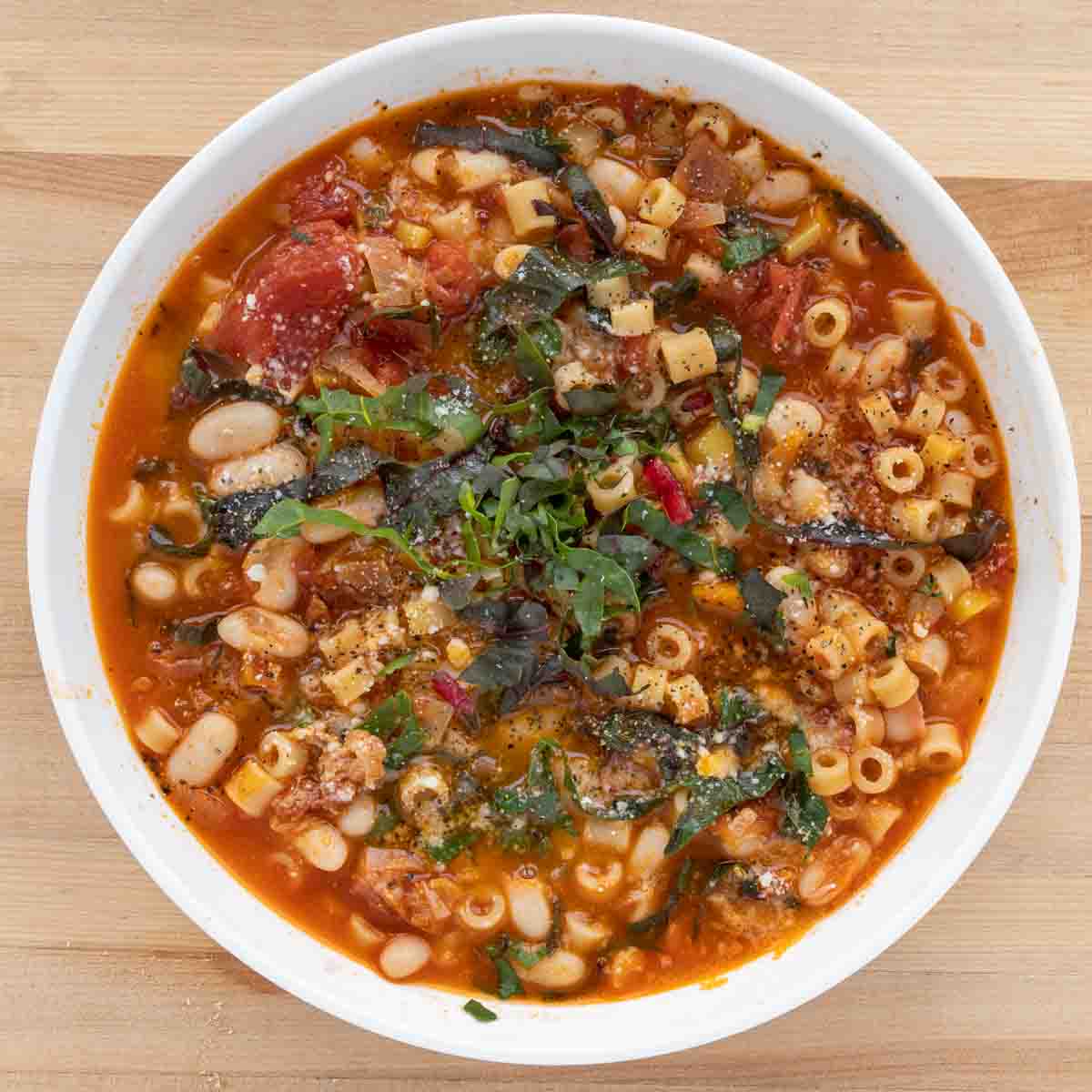 overhead view of pasta fagioli in a white bowl