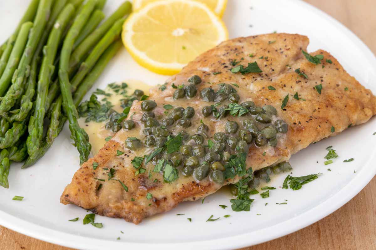 pan seared rockfish with a lemon caper sauce on a white plate