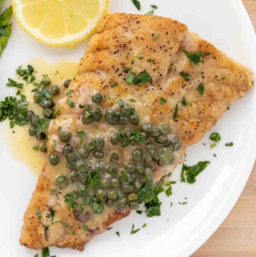pan seared rockfish with a lemon caper sauce on a white plate
