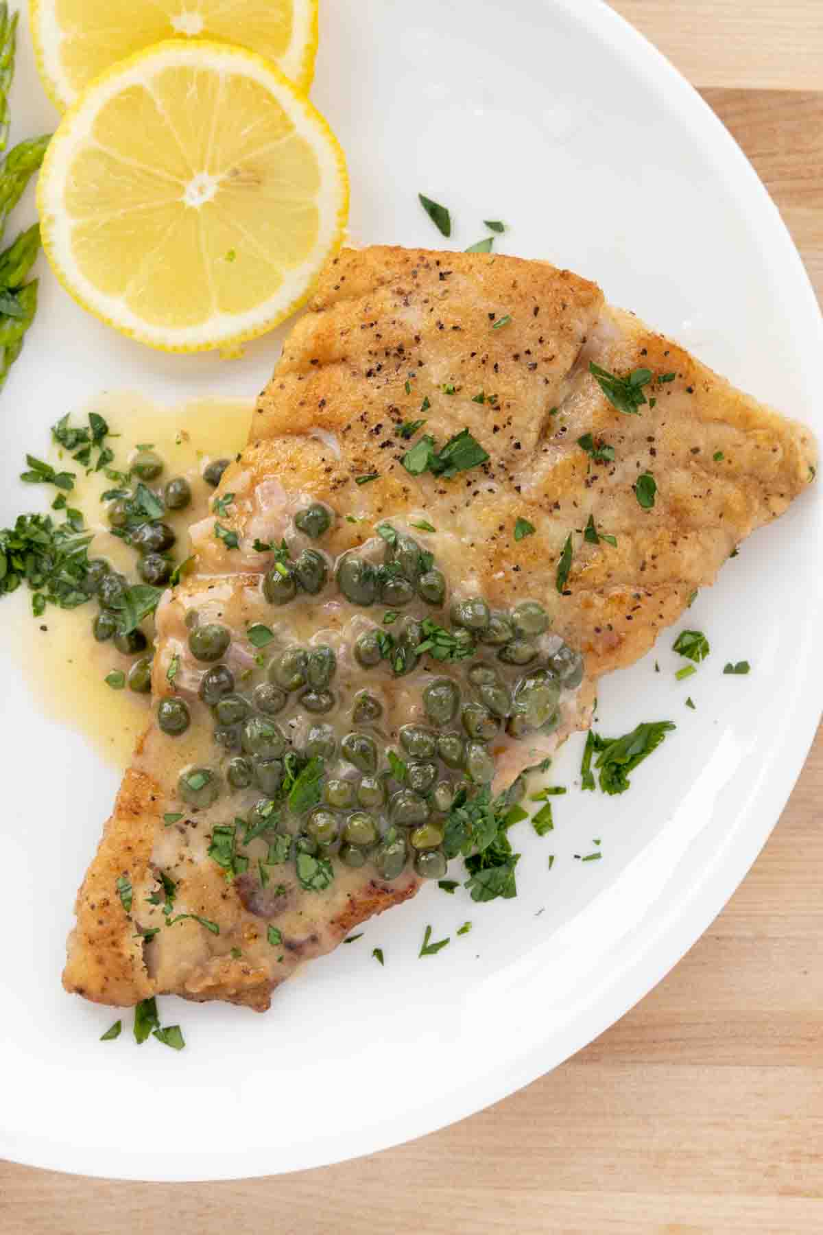 pan seared rockfish with a lemon caper sauce on a white plate
