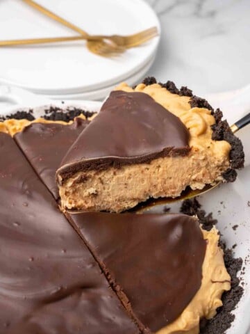 slice of peanut butter pie on a spatula being taken out of whole pie