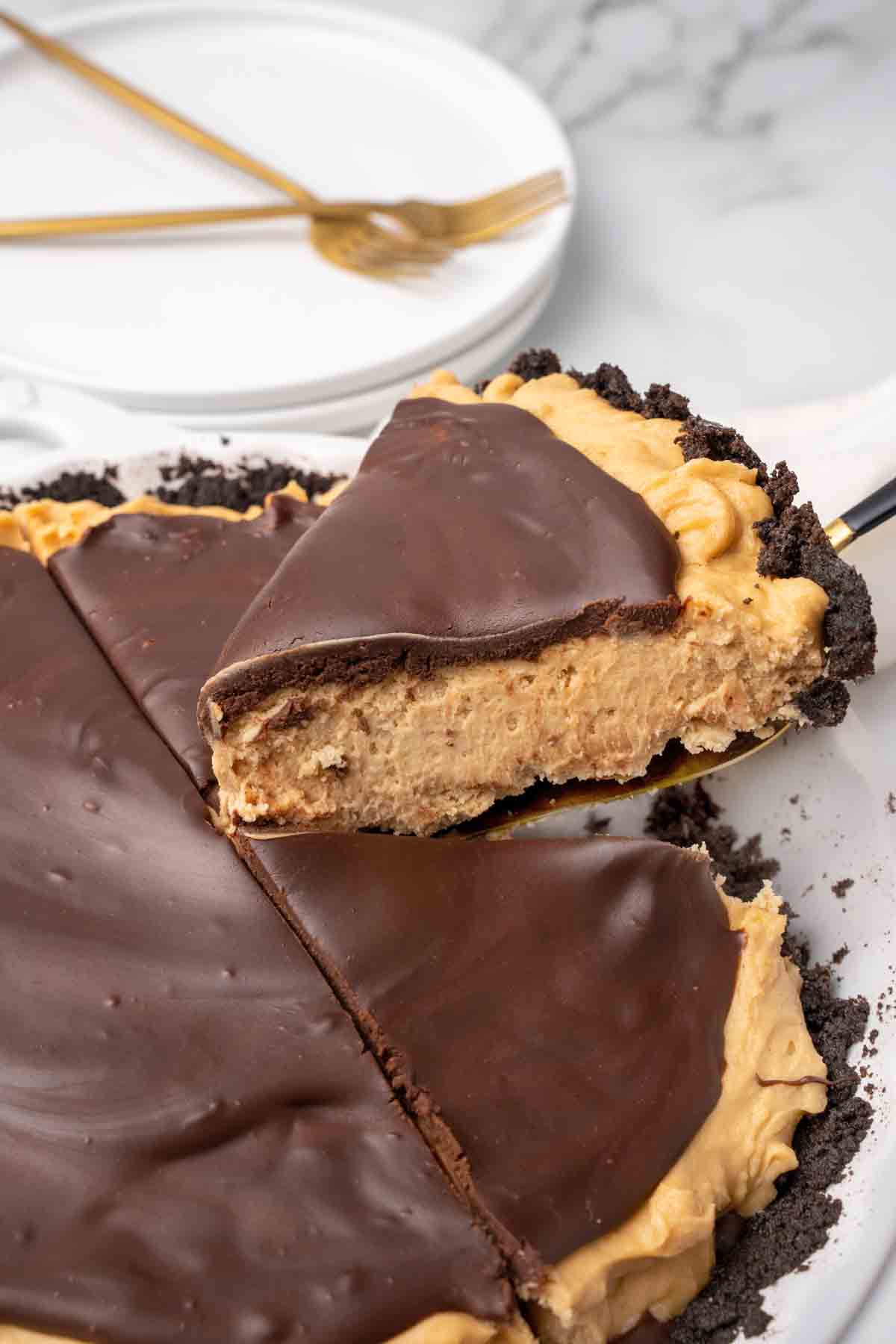 slice of peanut butter pie on a spatula being taken out of whole pie