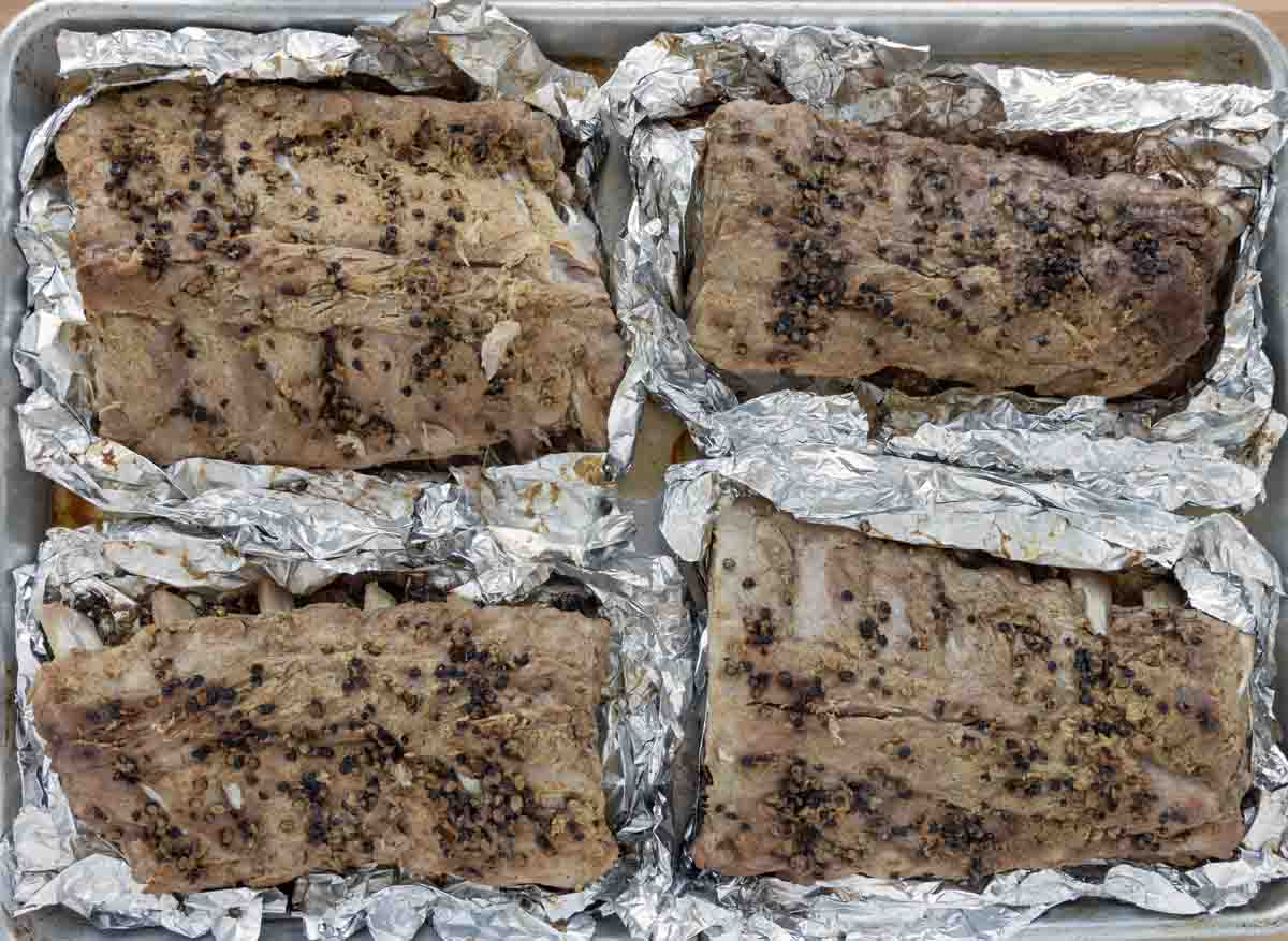 cooked ribs on a sheet pan with foil cut back