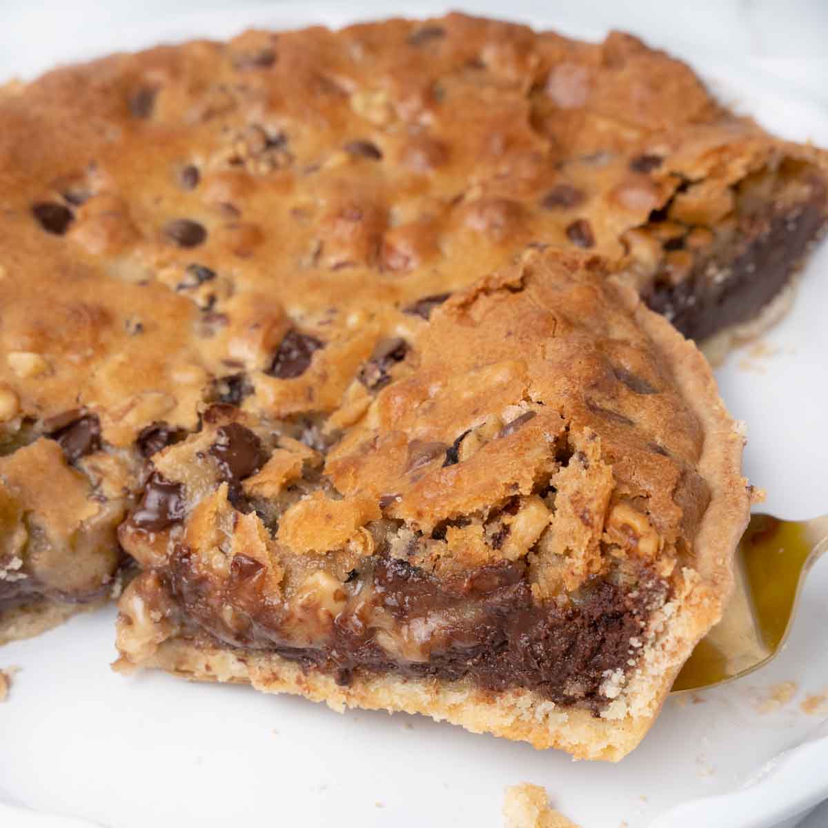 slice of cookie pie on a spatula being taken out of the whole pie