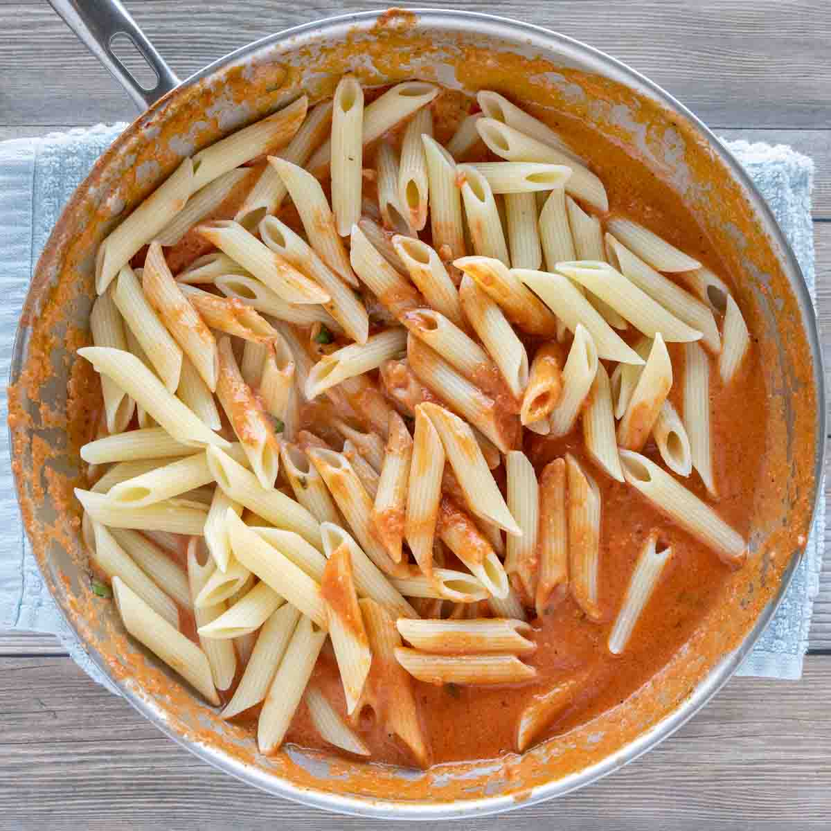 penne added into the pan of vodka sauce