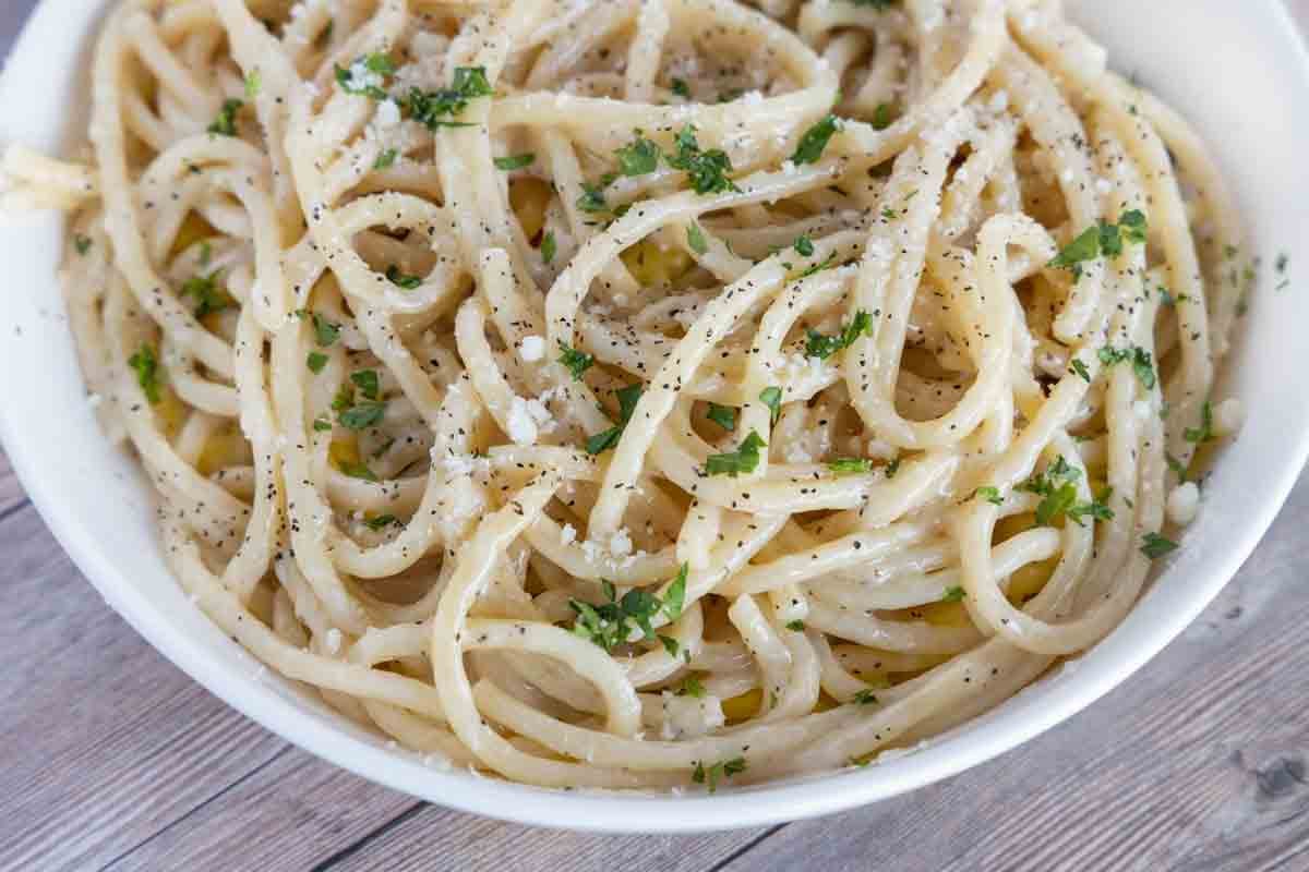 close up of cacio e pepe in a white bowl