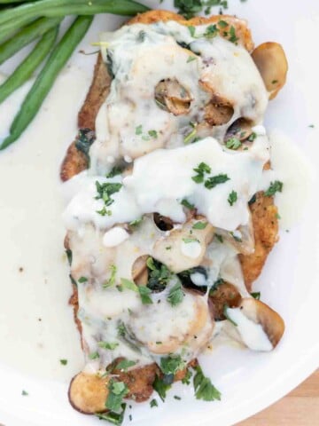 chicken florentine with supreme sauce on a white plate