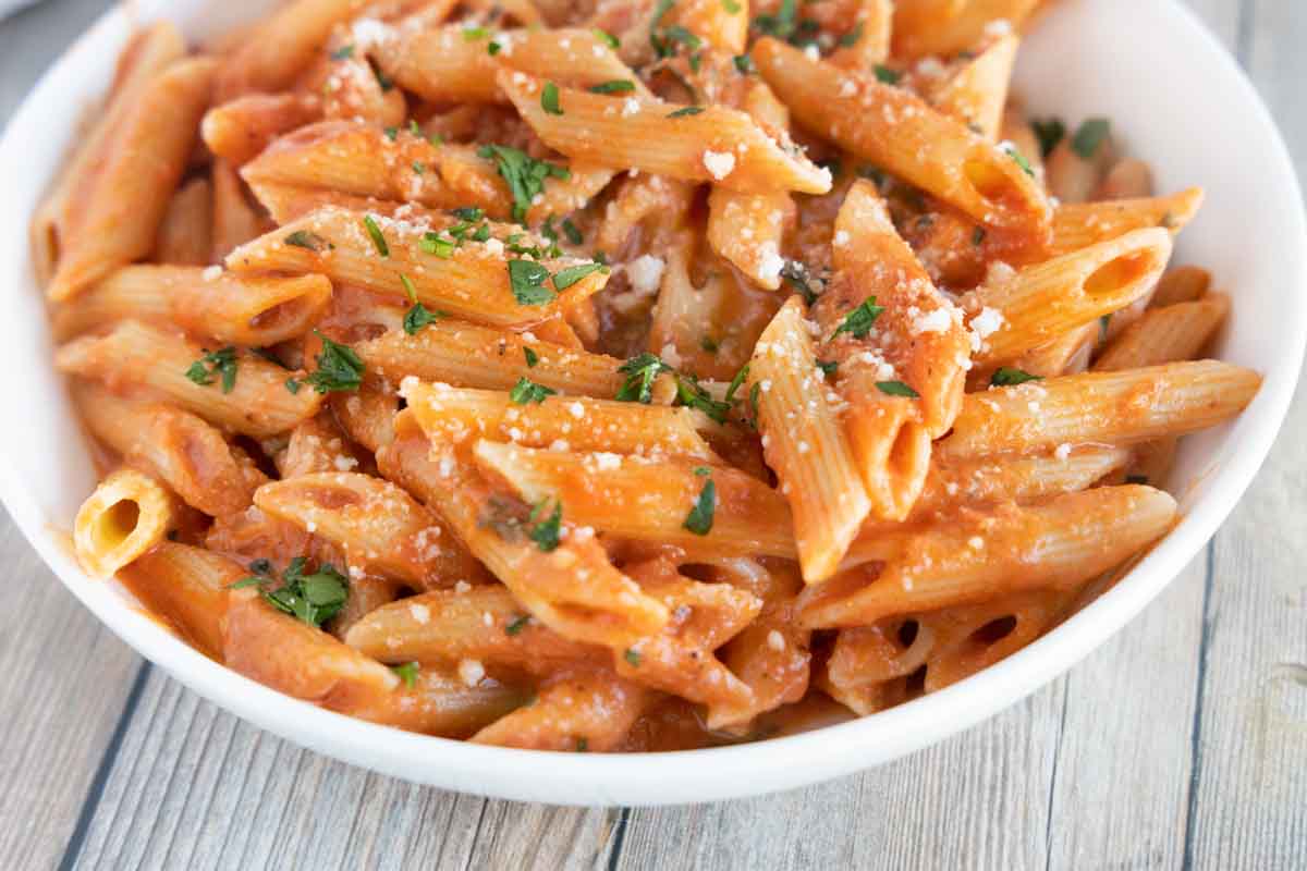 close up of penne alla vodka in a white bowl