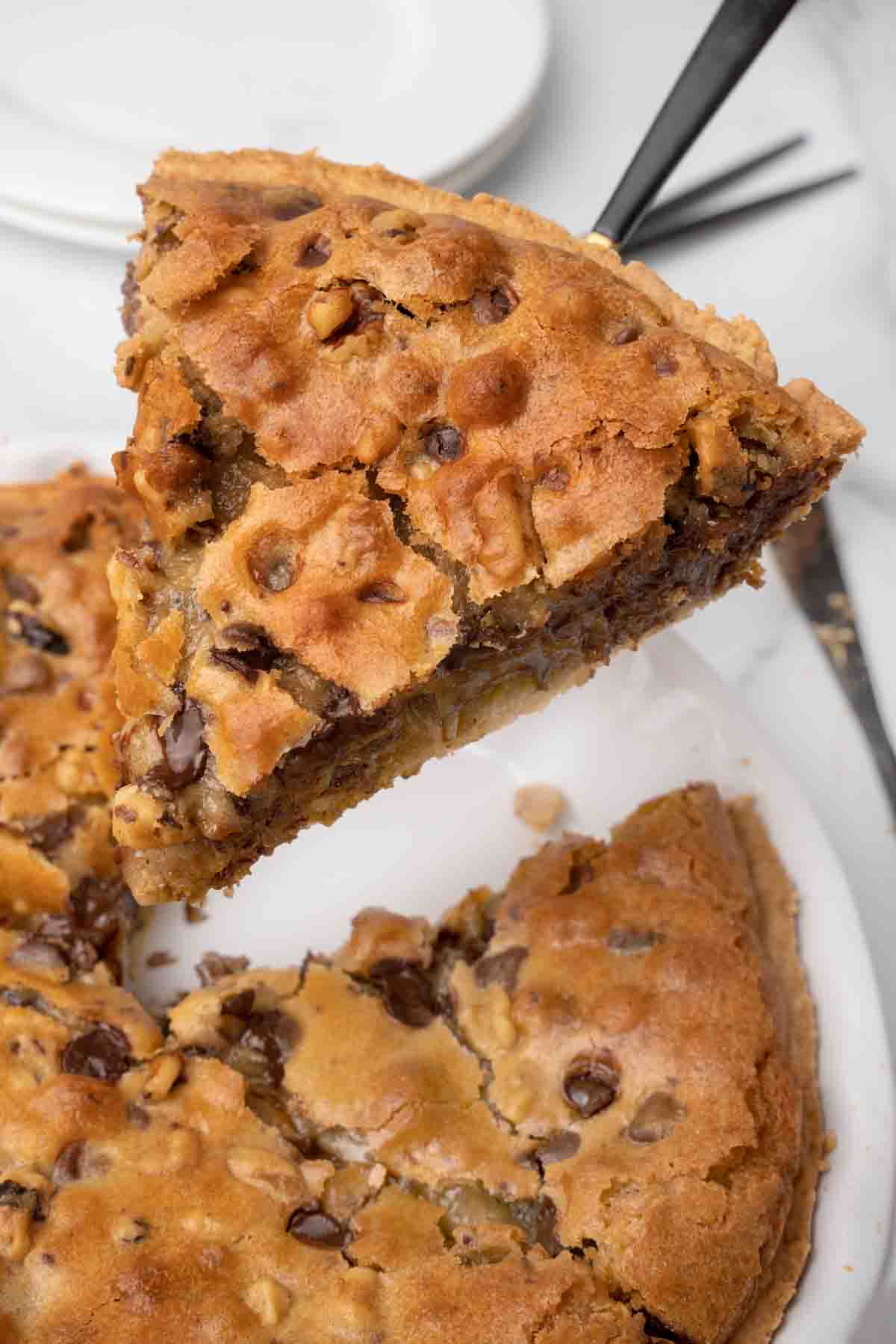 slice of cookie pie on a spatula being taken out of the whole pie