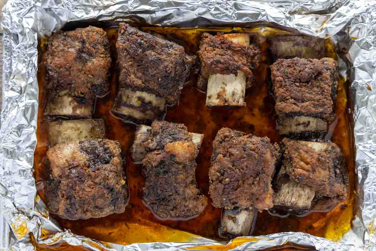 cooked short ribs in a foil lined pan