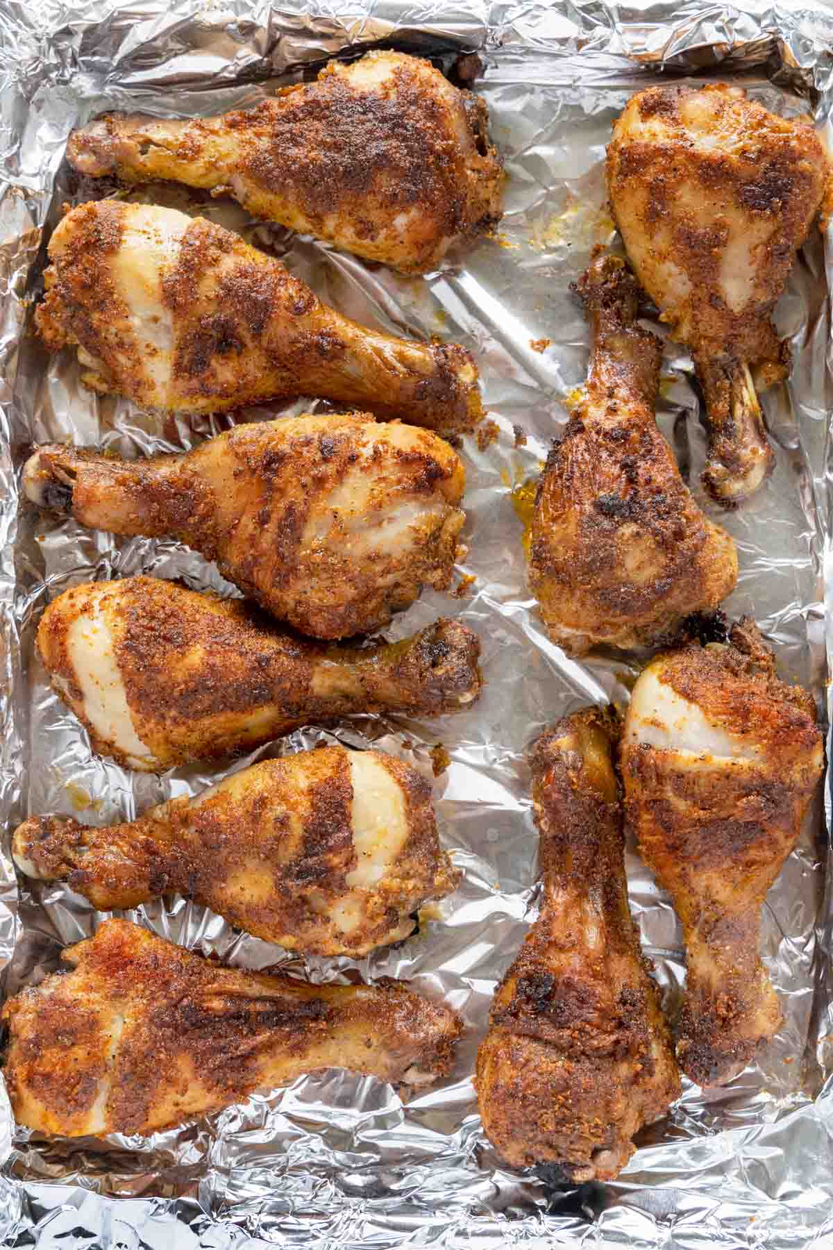 seasoned crispy chicken legs on a foil wrapped tray