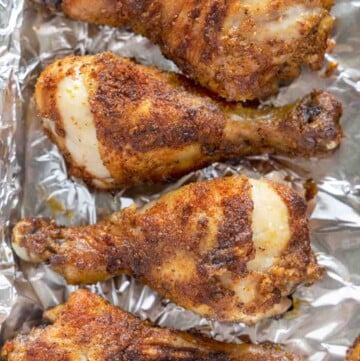 seasoned crispy chicken legs on a foil wrapped tray