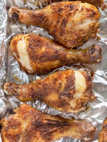 seasoned crispy chicken legs on a foil wrapped tray