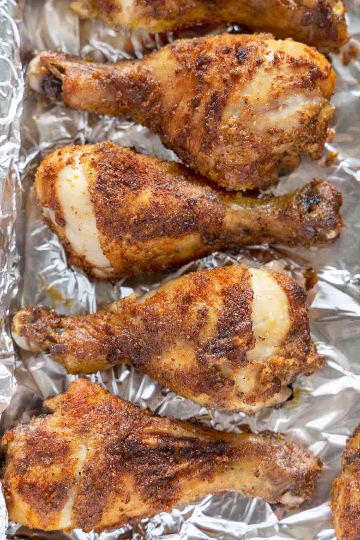 seasoned crispy chicken legs on a foil wrapped tray