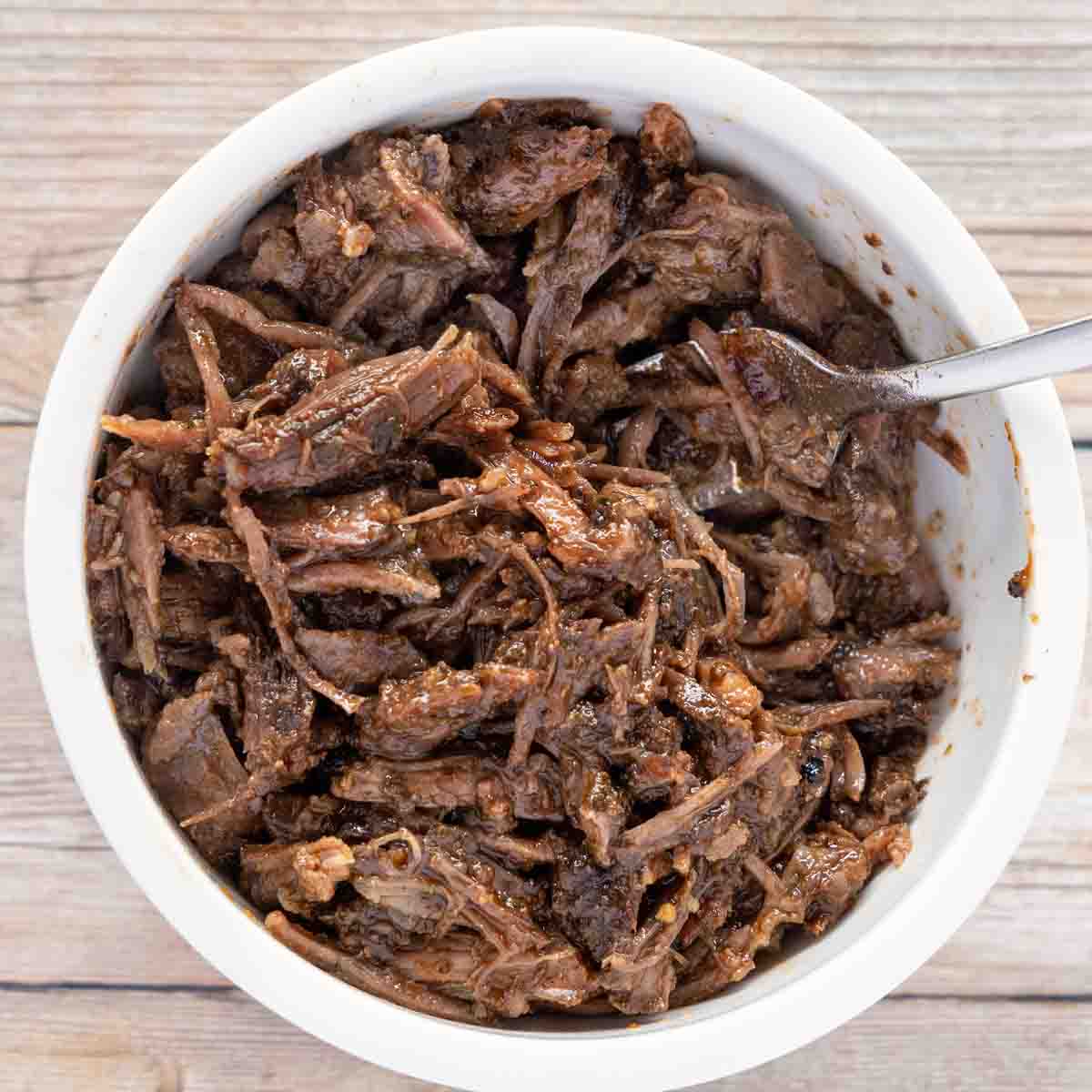 pulled short rib of beef in a white bowl