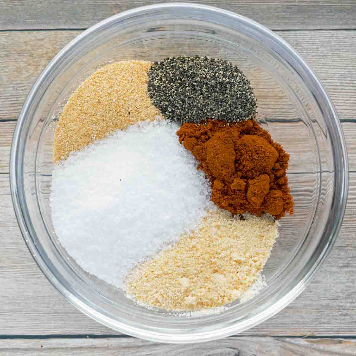 spices for the chicken legs in a glass bowl