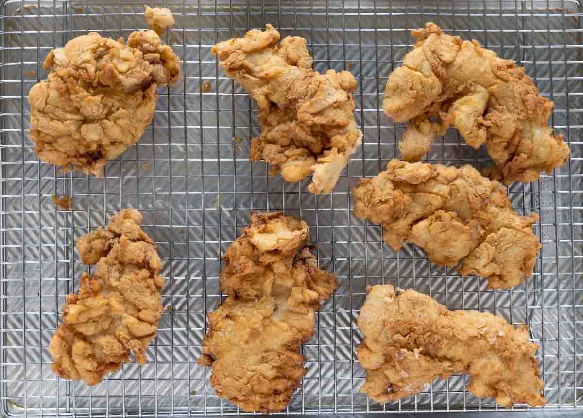 fried chicken tenders draining on a wire rack