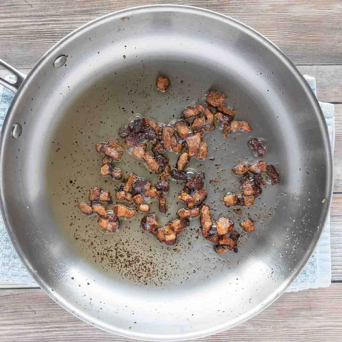 guanciale sautéd in a large frying pan