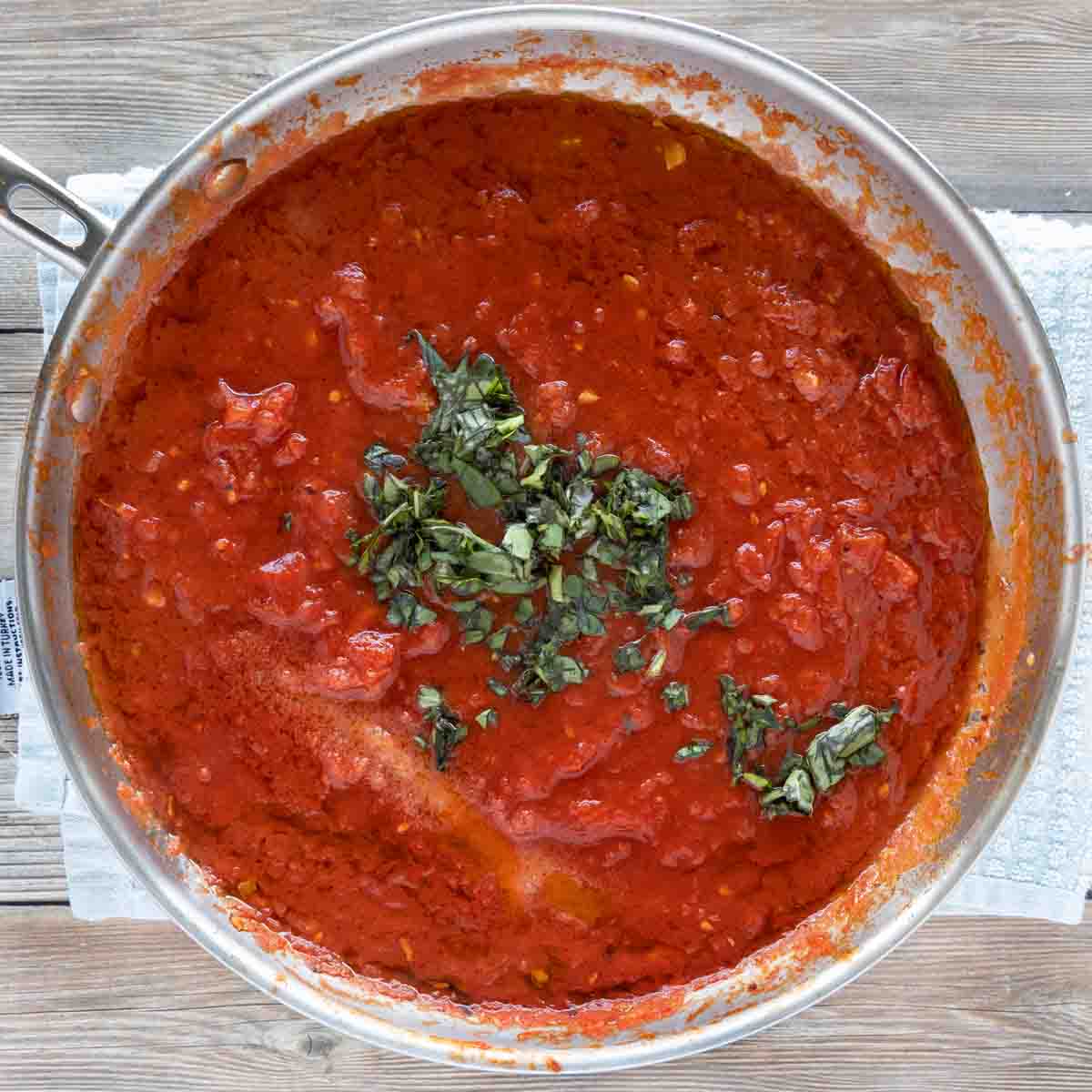 basil added to skillet with tomato mixture