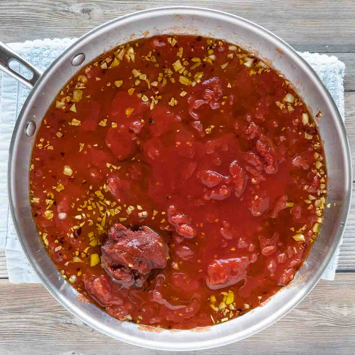 whole tomatoes and tomato paste added to skillet