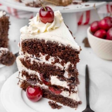 slice of Black Forest Cake on a white plate with a fork.