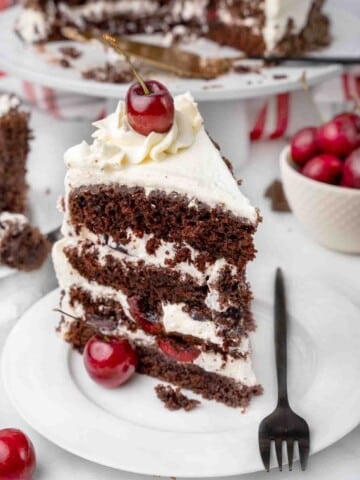 slice of Black Forest Cake on a white plate with a fork.