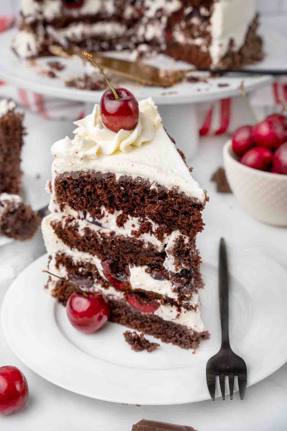 slice of Black Forest Cake on a white plate with a fork.