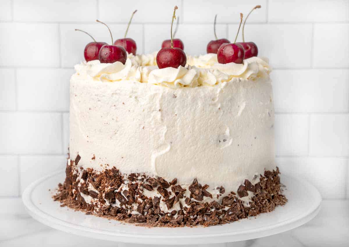 Whole Black Forest Cake on a white cake stand