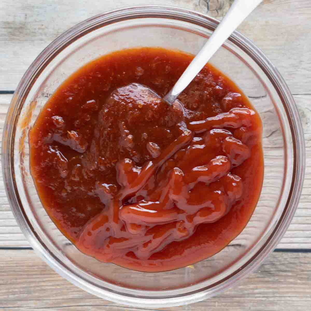 ketchup and chili sauce in a glass bowl with spoon.