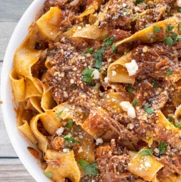 partial view of ragu napoletano over pappardelle in white bowl
