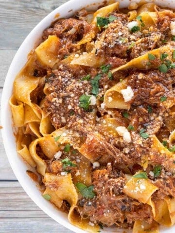 partial view of ragu napoletano over pappardelle in white bowl