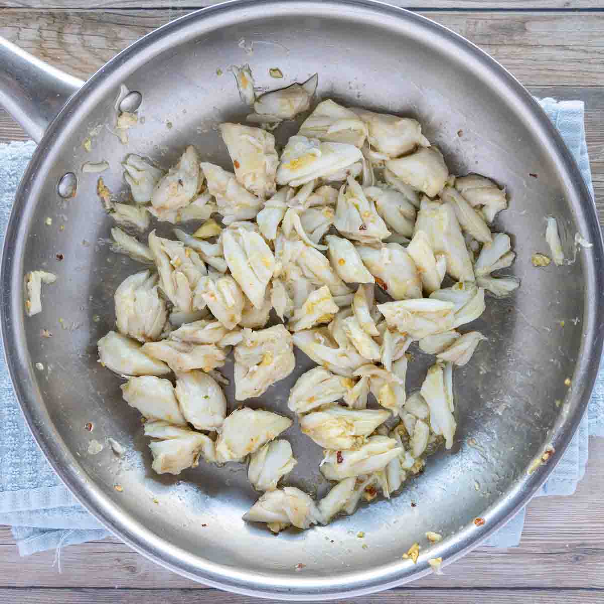 crab meat add to the pan with garlic and oil.