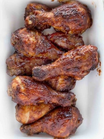 barbecue chicken legs on white platter