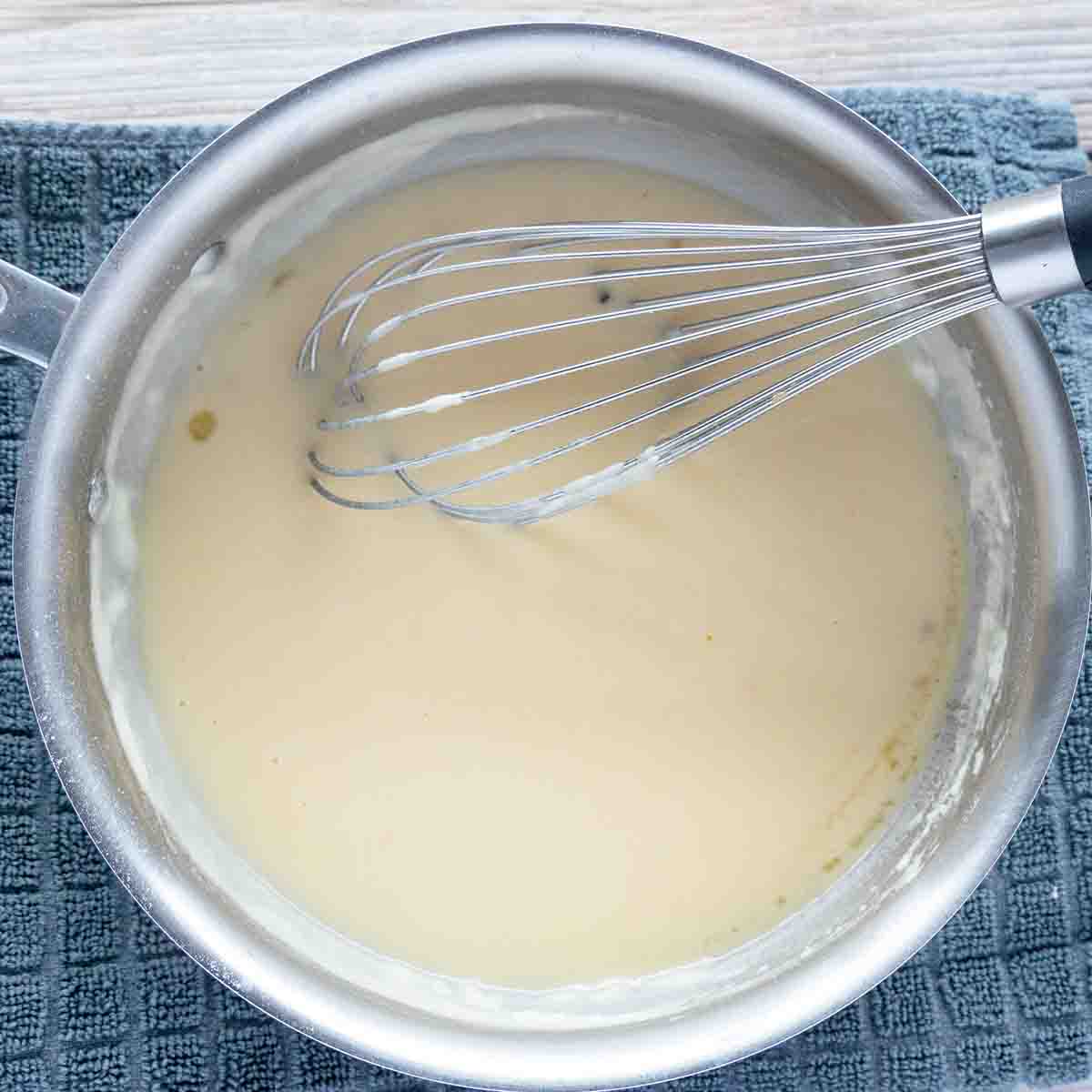 Turkey gravy in a small pot with wire whisk