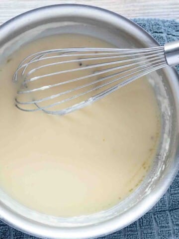 partial view of saucepan with turkey gravy and a whisk