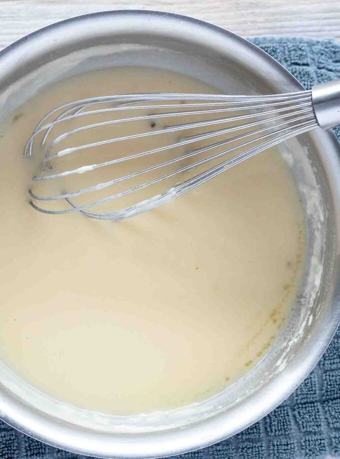 partial view of saucepan with turkey gravy and a whisk