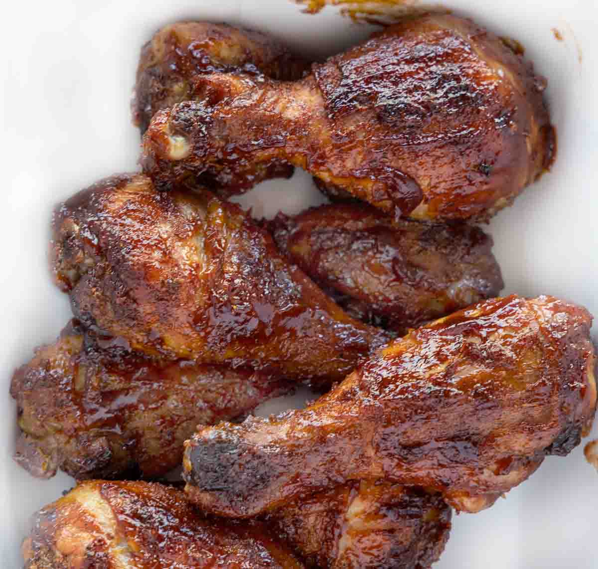 baked bbq chicken drumsticks on white platter