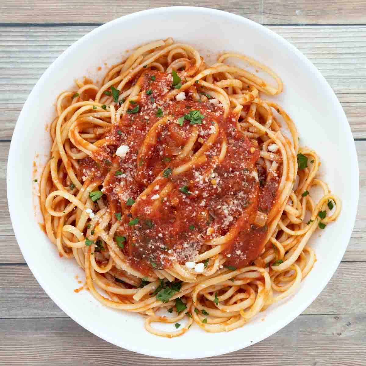 spaghetti with marinara sauce on white plate.