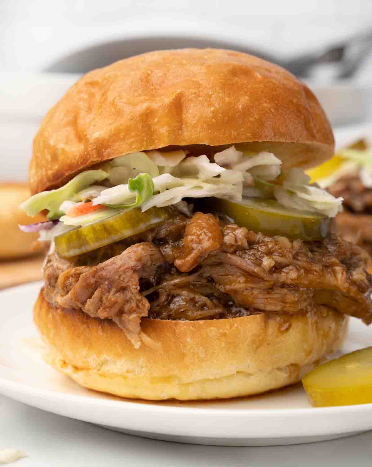 pulled pork bbq sandwich with cole slaw on a white plate