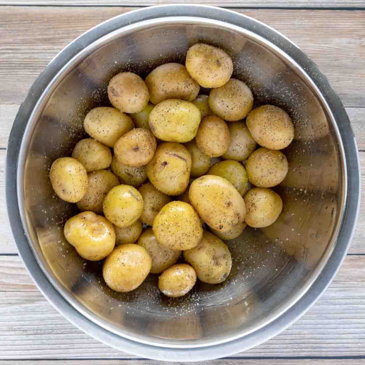 oiled baby potatoes in a stainless steel bowl
