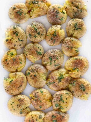 Baked smashed potatoes on a white platter