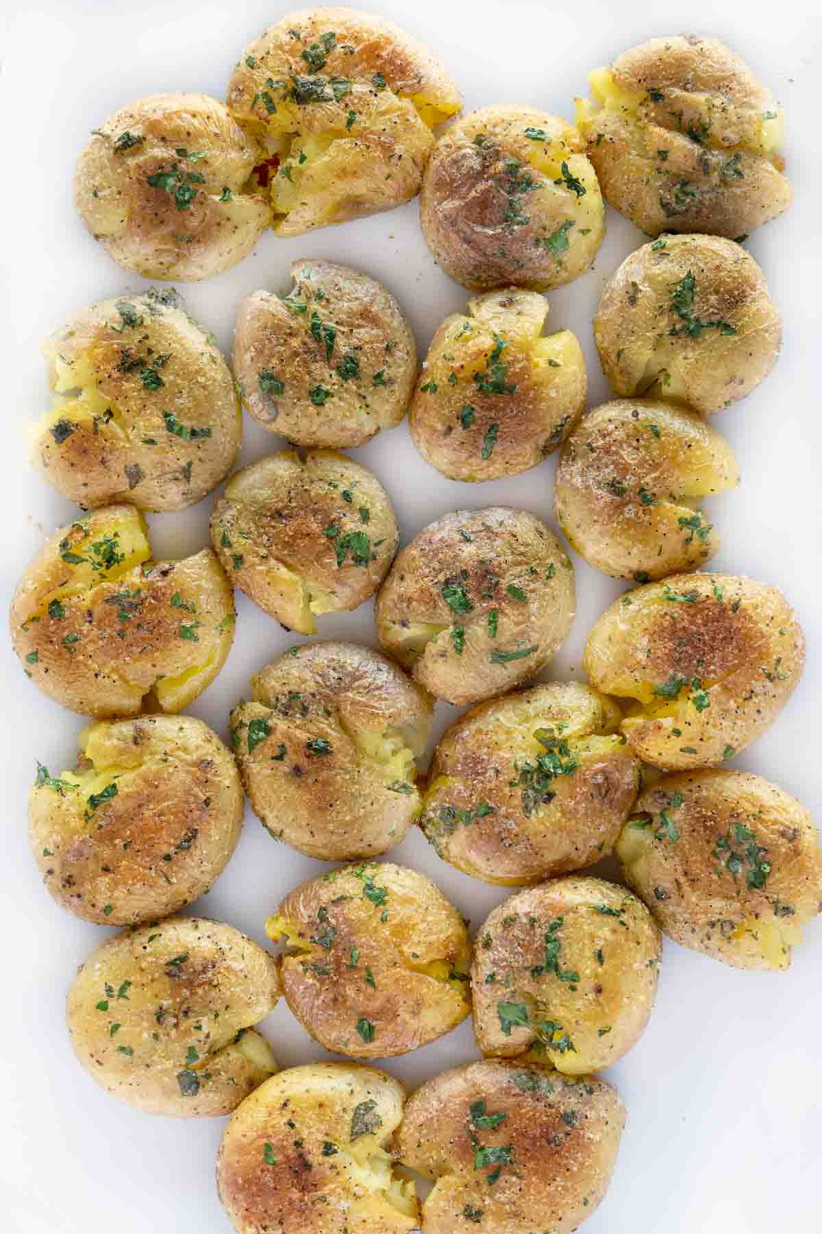 Baked smashed potatoes on a white platter