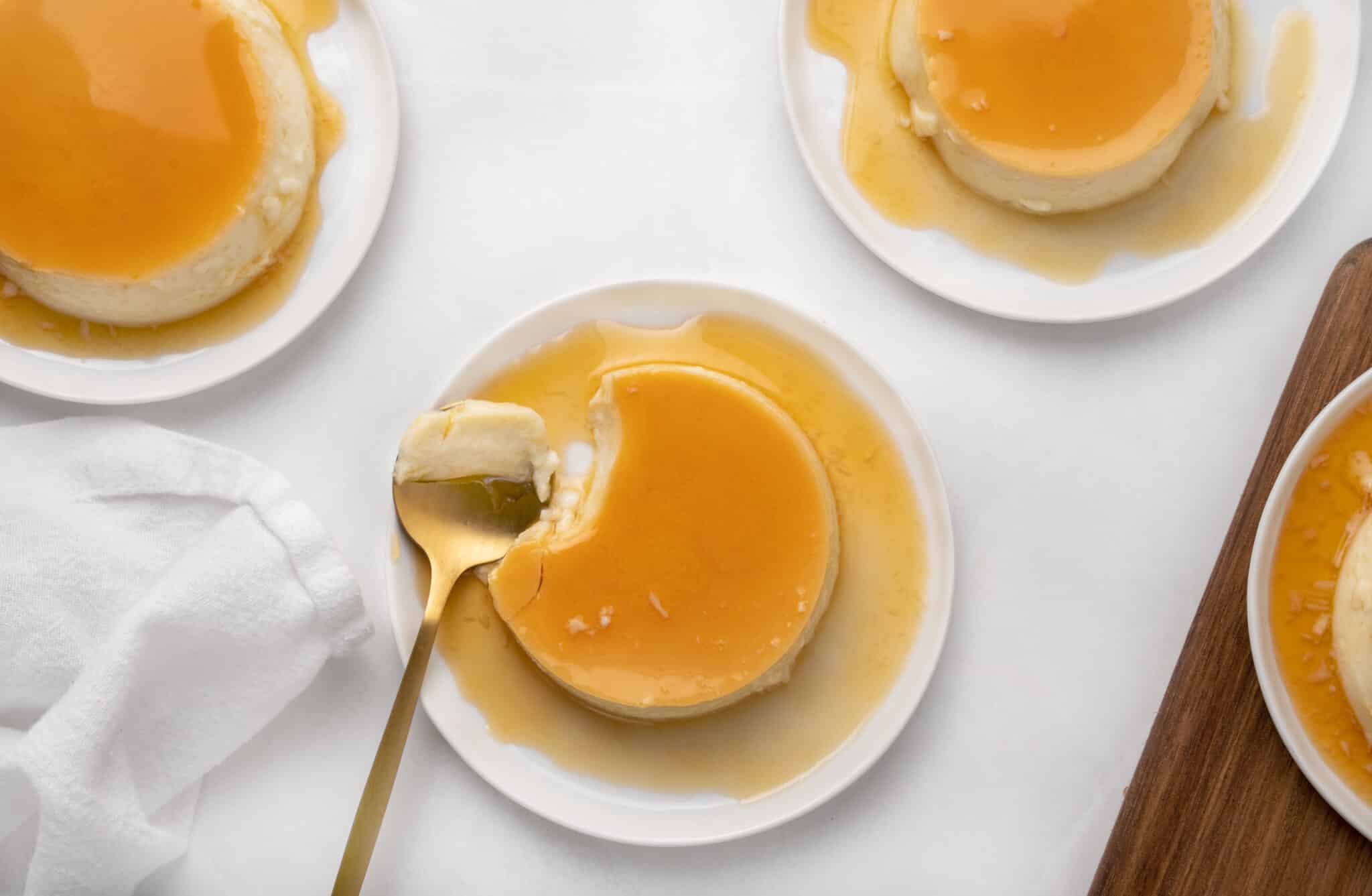 3 white plates of flan with caramel sauce