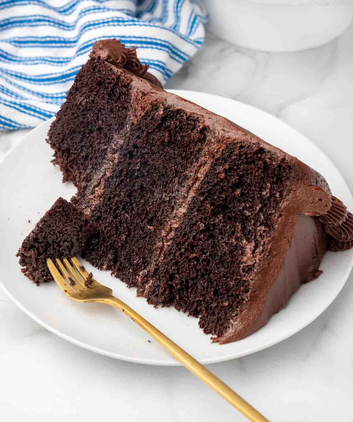 slice of chocolate cake with a fork on a white plate
