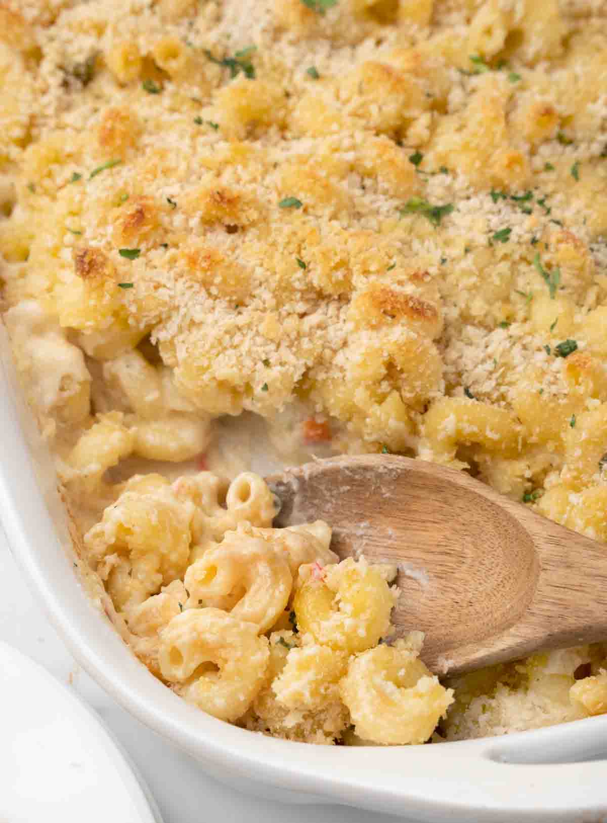 truffle mac and cheese in a casserole dish with a wooden spooon