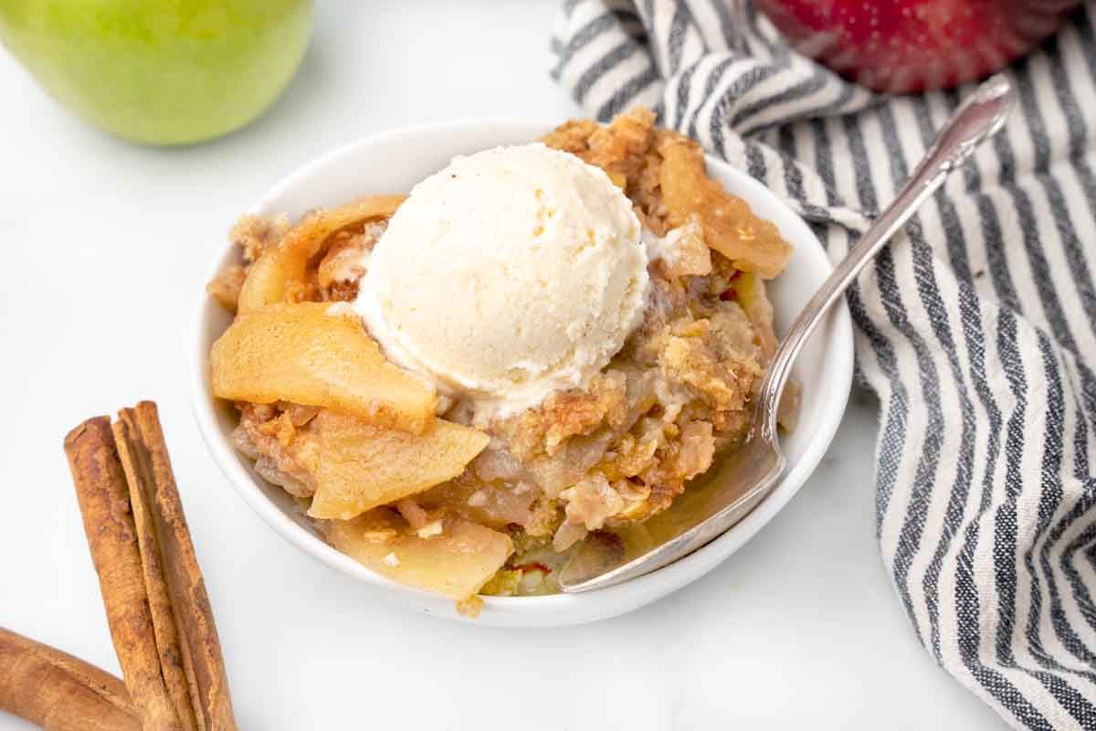 white bowl of apple crisp with ice cream