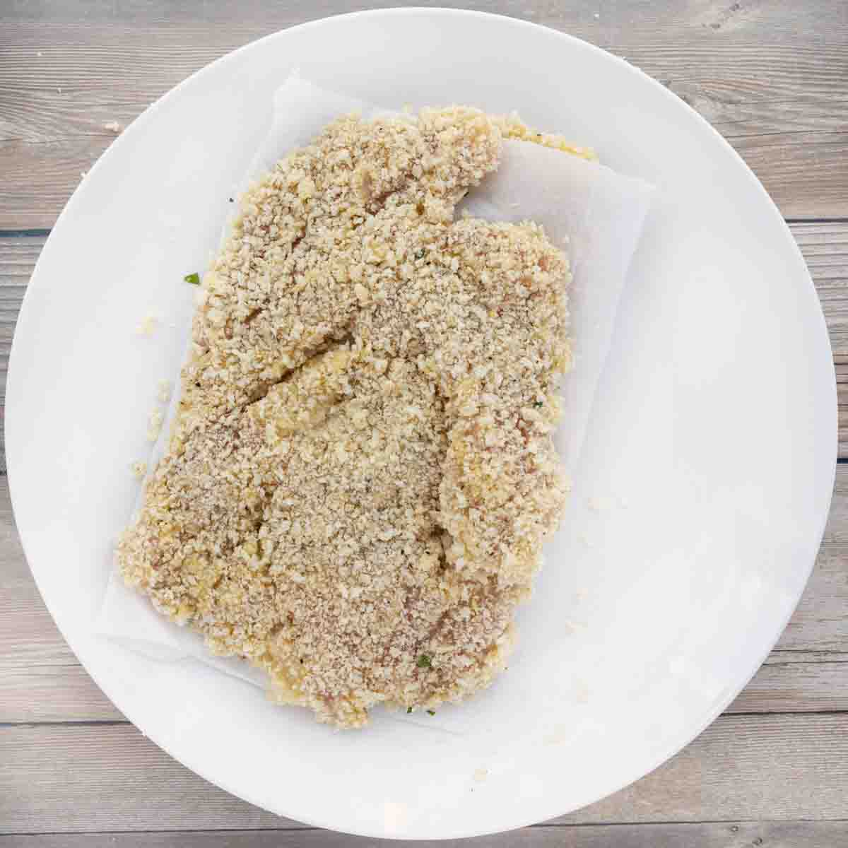 breaded cutlets on a white plate.